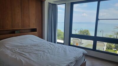 Bedroom with large window and ocean view