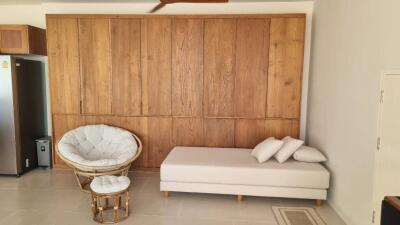 Modern living room with wooden panel wall, white lounge chair, and cozy seating