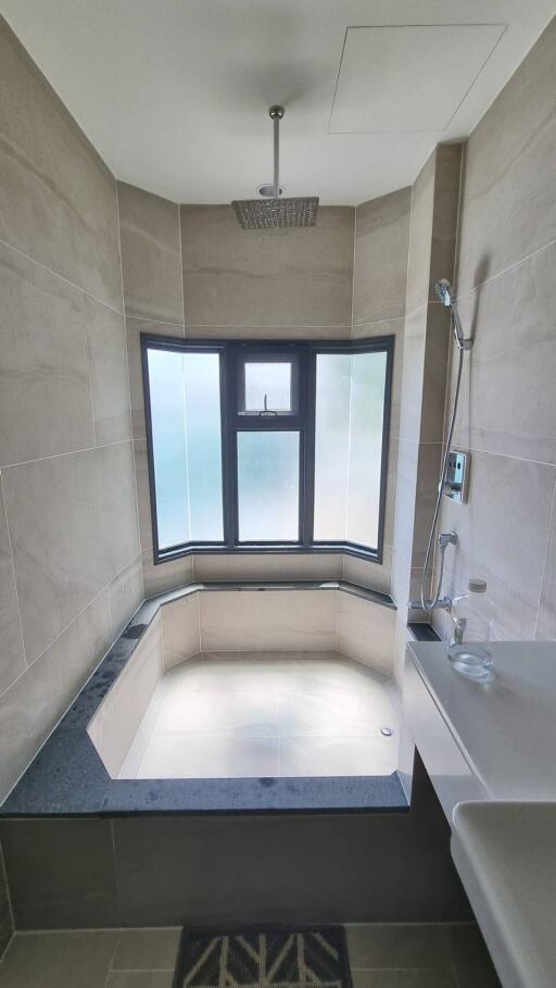 Modern bathroom with a large bathtub and frosted windows