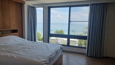 bedroom with large window and ocean view