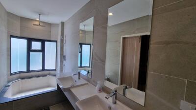 Modern bathroom with double sinks and a large bathtub