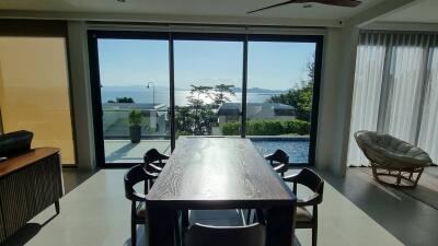 Dining area with large glass windows overlooking ocean view