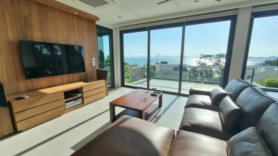 Modern living room with a leather sofa and a view of the sea through large windows
