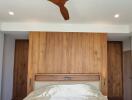 Bedroom with wooden accent wall and ceiling fan