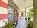 Covered exterior walkway with large windows and plants