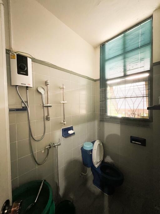 Bathroom with water heater and blue toilet