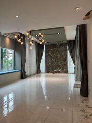 Spacious and elegant living room with modern chandelier, large windows, and floor-to-ceiling curtains.