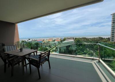 Balcony with outdoor seating overlooking the cityscape and ocean