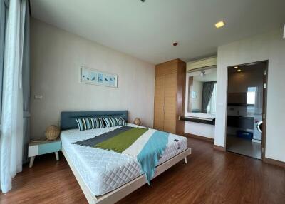 Modern bedroom with wooden flooring, double bed, and attached bathroom