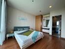 Modern bedroom with wooden flooring, double bed, and attached bathroom