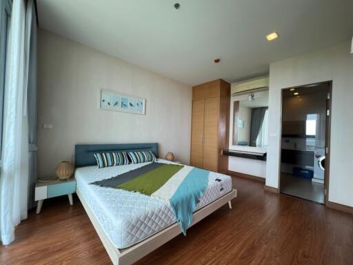 Modern bedroom with wooden flooring, double bed, and attached bathroom