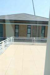 View of a spacious terrace area with railings and a building in the background