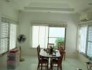 Bright dining room with large windows and white flooring