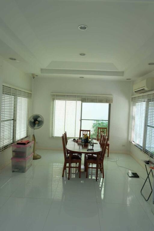 Bright dining room with large windows and white flooring