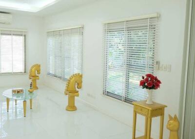 Bright living room with white tiled floor and unique yellow horse decorations