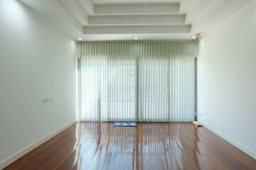 Spacious living room with large windows and wooden floor