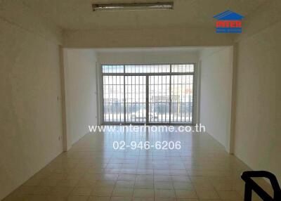 Empty living room with large windows and tiled floor