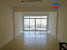 Empty living room with large windows and tiled floor