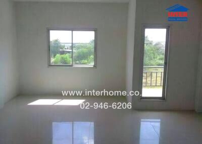 Empty room with windows and a door leading to a balcony