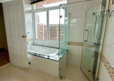 Spacious bathroom with glass-enclosed shower and bathtub