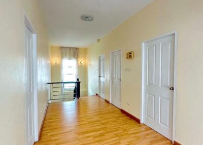 Spacious hallway with hardwood floors and doors leading to different rooms