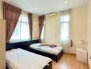 Bedroom with two single beds, wooden flooring, and natural light