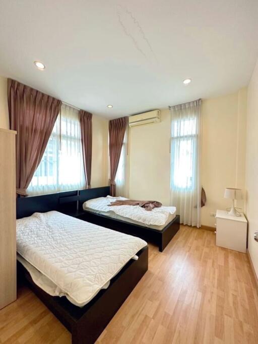 Bedroom with two single beds, wooden flooring, and natural light