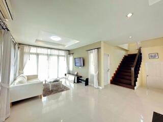 Spacious living room with modern furniture and a staircase