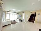 Spacious living room with modern furniture and a staircase