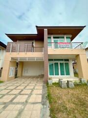 Two-storey house for rent with a paved driveway, balcony, and front lawn