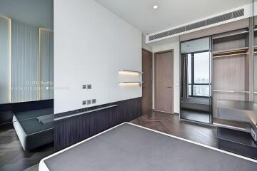 Modern bedroom with large mirrors, built-in shelves, window view, and a minimalist design.