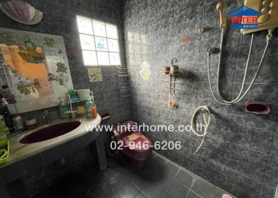 Dimly lit bathroom with dark tiles