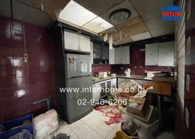 Cluttered kitchen with purple tiles and appliances