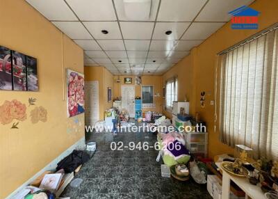 Cluttered living room with yellow walls and tiled floor