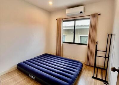Minimalist bedroom with an air mattress, window, and air conditioning