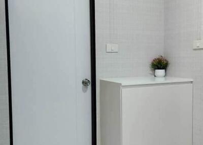Minimalist room with a white door and a white cabinet