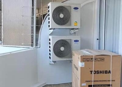 Balcony with air conditioning units and a boxed washing machine