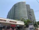 Modern multi-story apartment building with nearby convenience store