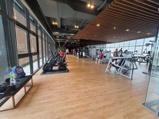 Modern gym with various exercise equipment and people working out