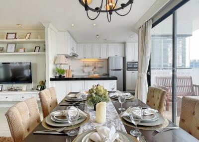 Open dining area with a view of the kitchen, elegant table setting, and access to a balcony