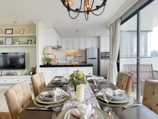 Open dining area with a view of the kitchen, elegant table setting, and access to a balcony