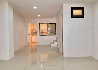 Spacious living area with tiled flooring and modern lighting