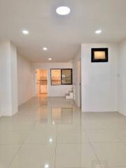 Spacious living area with tiled flooring and modern lighting