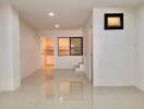 Spacious living area with tiled flooring and modern lighting