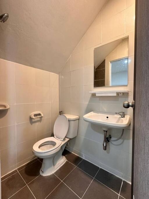 Bathroom with a toilet, sink, and mirror