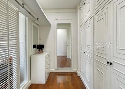 Modern well-lit bedroom with large mirror and ample storage space