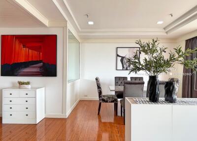 Modern dining area with hardwood floors, artwork, and plants