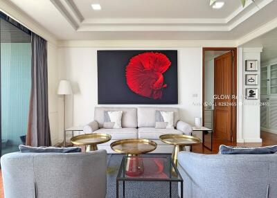 Modern living room with grey sofas, gold coffee tables, and vibrant red artwork