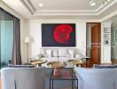 Modern living room with grey sofas, gold coffee tables, and vibrant red artwork