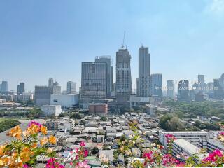 City skyline view from balcony with flowers in the foreground